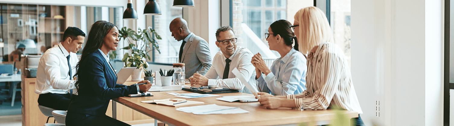stock-photo-smiling-group-of-diverse-businesspeople-discussing-paperwork-together-while-having-a-meeting-around-1494983738