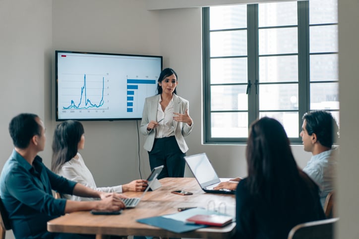 An executive gives a presentation about insurance fraud trends in a small meeting room.