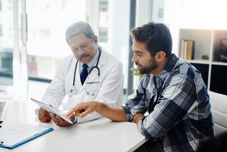 Doctor and patient having discussion in doctor’s office. 