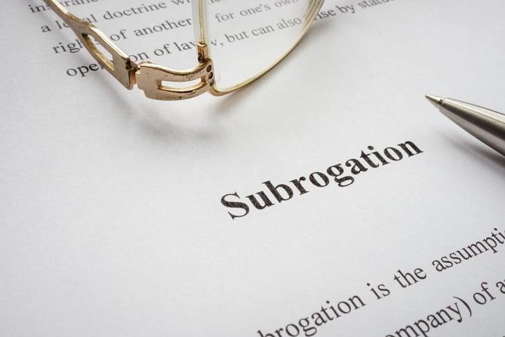 A piece of paper with info about subrogation and old glasses.